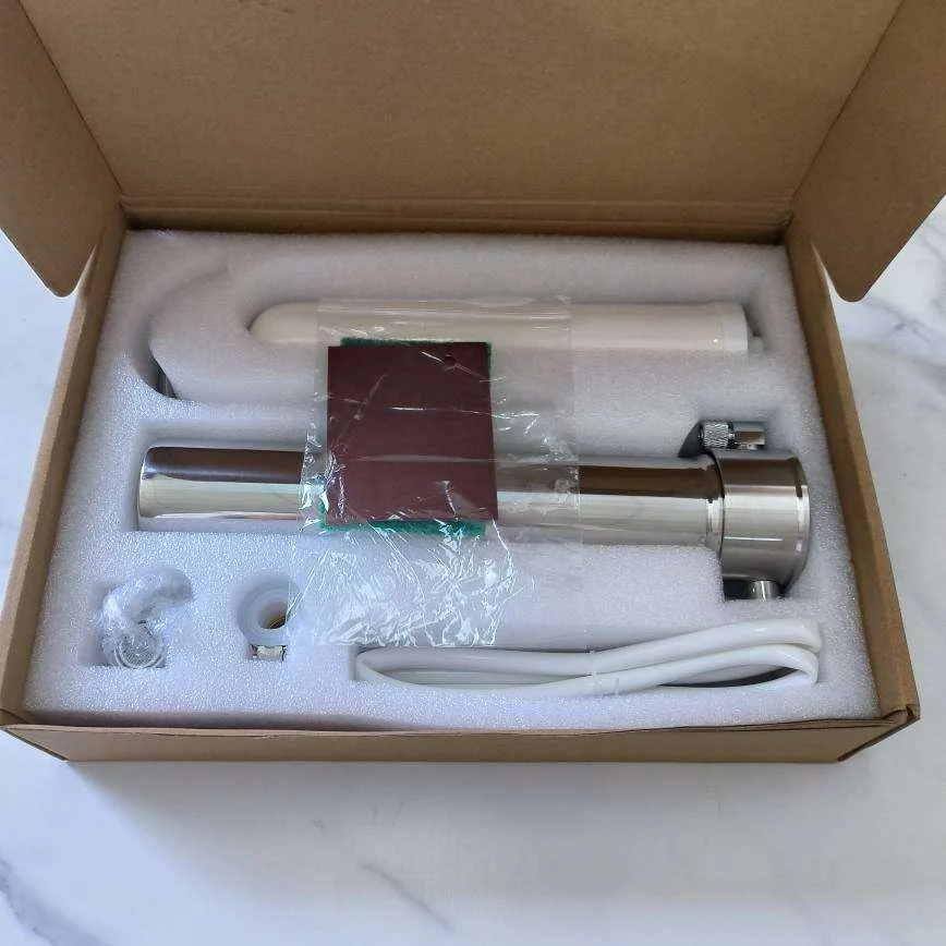 Översiktsbild av Kranfilter XL-satsen inuti sin förpackning, komplett med aktivt kolfilter, kopplingar och slang. Perfekt för renare vatten direkt från kranen. Redo att installeras.