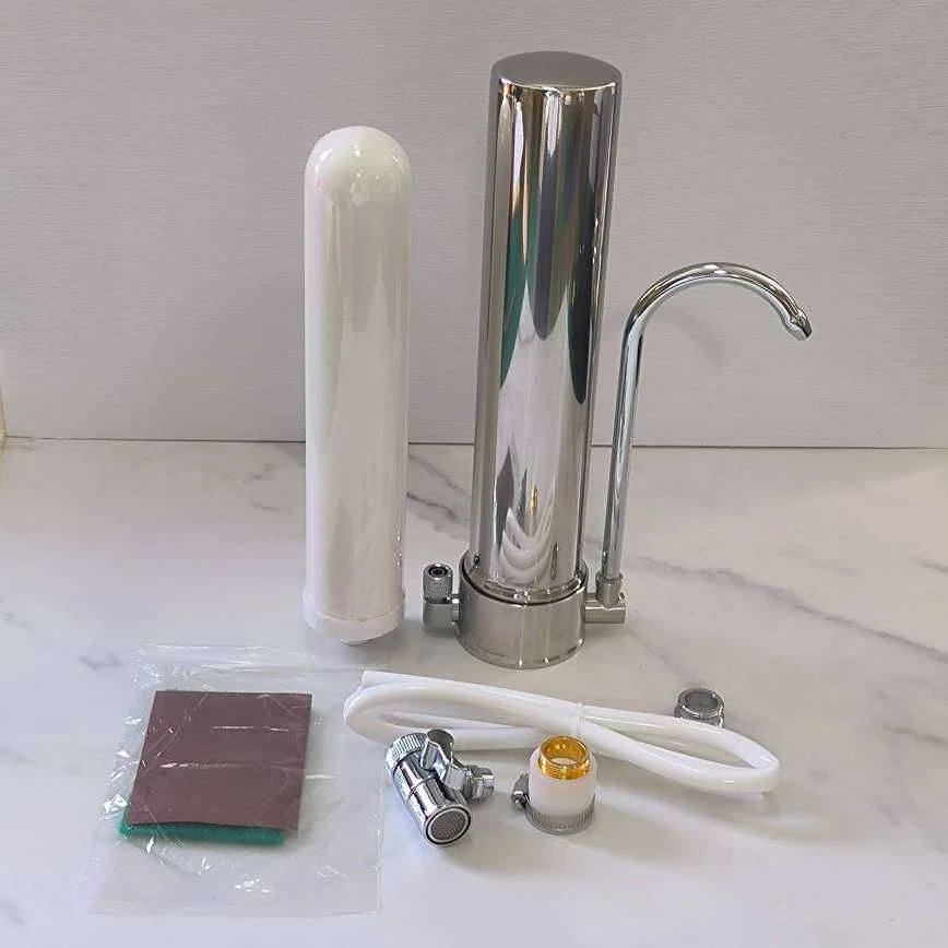 Produktbild som visar en komplett uppsättning för Kranfilter XL. Medföljer gör ett aktivt kolfilter, kromfärgad kran och diverse slangar och adaptrar, redo för installation. Perfekt för renare vatten direkt från kranen.